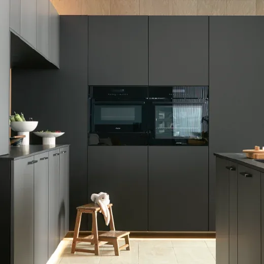 Moderne grifflose Küche in Anthrazit matt mit integrierten Einbaugeräten und Holz-Oberschränken