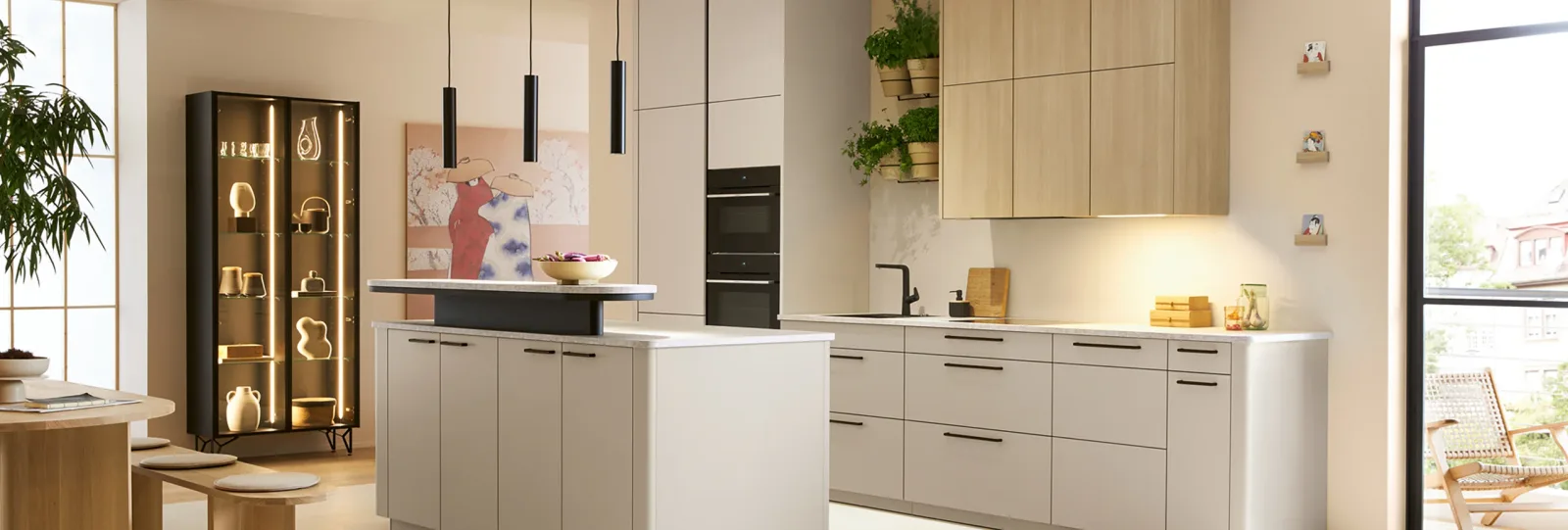 Moderne Wohnküche in Sandbeige matt mit Kücheninsel, grifflosen Fronten und eleganter Vitrine mit Beleuchtung